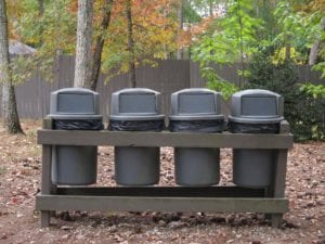 image of 4 trash containers with black can liners outdoors