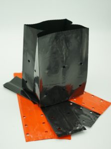image of custom grow bags: an unfolded black plant bag on top of orange and black seed bags
