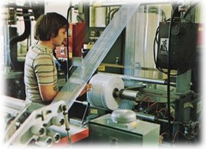 an old image of a staff member working at a blown-film extrusion plant at TDI Custom Packaging that is a provider of plastic products
