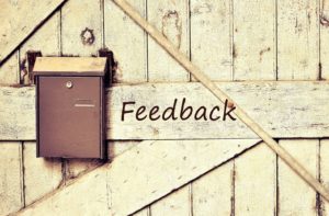 Image of a mailbox on a wooden door with the text "Feedback"