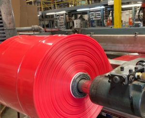 image of a roll of red poly bags on a production line