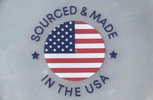 image of text that says "SOURCED & MADE IN THE USA" and the American flag printed in a circle in the middle with a white plastic background